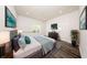 A spacious staged bedroom features a large TV, artwork, decor, and wood-look flooring at 300 Mitnik Dr, Deltona, FL 32738