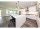 Large kitchen with a big island featuring white cabinetry and sleek stainless steel appliances at 300 Mitnik Dr, Deltona, FL 32738