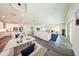 Staged living room boasts an open concept with large windows, wood flooring, and white furnishings at 300 Mitnik Dr, Deltona, FL 32738
