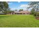 Large backyard featuring a covered patio, pool, and expansive green lawn at 3215 Greens Ave, Orlando, FL 32804