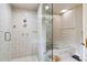 Shower with glass door and bathtub featuring gold fixtures and cream colored tile at 3215 Greens Ave, Orlando, FL 32804