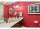 Bathroom with a vintage vanity and red wallpaper; decorative lighting complements the unique aesthetic at 3215 Greens Ave, Orlando, FL 32804