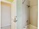Bathroom featuring a tile shower-tub combo and patterned wallpaper next to an open doorway at 3215 Greens Ave, Orlando, FL 32804