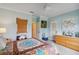 Bedroom with light blue walls, neutral carpet, patterned bedding, with a wall of artwork and a ceiling fan at 3215 Greens Ave, Orlando, FL 32804