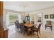 Bright dining room with a large hardwood table, chandelier, and view of landscaped yard at 3215 Greens Ave, Orlando, FL 32804