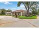 Spacious estate with circular driveway, beautifully maintained landscaping, and architectural details under a blue sky at 3215 Greens Ave, Orlando, FL 32804