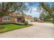 Side view of the home with a three-car garage, private driveway, and well-maintained landscaping at 3215 Greens Ave, Orlando, FL 32804