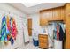 Bright laundry room featuring a tile floor, light colored walls, wood cabinets and an ironing board at 3215 Greens Ave, Orlando, FL 32804