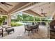 Covered outdoor space perfect for relaxing, with dining area, lounge seating, grilling station, and a view of the pool at 3215 Greens Ave, Orlando, FL 32804