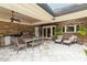 Spacious covered patio with outdoor kitchen, dining area, and lounge seating overlooking a beautifully landscaped yard at 3215 Greens Ave, Orlando, FL 32804
