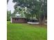 Brick home exterior with screen porch and large tree in a spacious green backyard at 3305 Robinson St, Zellwood, FL 32798