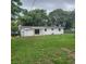 Exterior view of a single-story home with a spacious backyard surrounded by mature trees at 3305 Robinson St, Zellwood, FL 32798