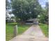 Exterior elevation of cozy home with mature landscaping and a long driveway at 3305 Robinson St, Zellwood, FL 32798
