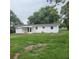 View of a single-story home with a spacious backyard surrounded by trees at 3305 Robinson St, Zellwood, FL 32798