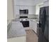 Updated kitchen with white cabinets, granite countertops and modern black appliances at 3305 Robinson St, Zellwood, FL 32798