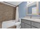 Bathroom featuring a blue wall, white tub, gray vanity with solid surface top, and neutral flooring at 339 Chinaberry Ave, Oviedo, FL 32765