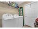 Bright laundry room equipped with a washer, dryer, storage shelf, and convenient access door at 339 Chinaberry Ave, Oviedo, FL 32765