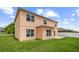 Backyard with grass and a two-story house with a concrete patio at 442 Churchill Ct, Kissimmee, FL 34759