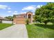 Inviting two-story home featuring an arched entryway, attached two-car garage, and a lush front lawn at 442 Churchill Ct, Kissimmee, FL 34759