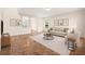 Staged living room featuring neutral furniture, earth-toned accents, and a view into the next room at 442 Churchill Ct, Kissimmee, FL 34759