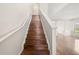 Elegant staircase featuring hardwood steps, white banisters, and an open view of the living area at 442 Churchill Ct, Kissimmee, FL 34759