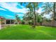 Beautiful backyard with lush green grass, tall trees, and a classic brick fire pit at 4739 Indian Gap Dr, Orlando, FL 32812