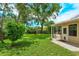 A lush backyard is showcased with mature trees, verdant grass, and an inviting patio at 4739 Indian Gap Dr, Orlando, FL 32812