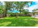A spacious backyard boasts mature trees, lush grass, a classic brick fire pit, and a wood fence at 4739 Indian Gap Dr, Orlando, FL 32812