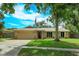 Charming single-story home featuring a manicured lawn, stone accents, and an attached two-car garage at 4739 Indian Gap Dr, Orlando, FL 32812