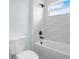 Modern bathroom features a sleek tub with wavy tile surround and stylish black fixtures at 527 Rio Grande Dr, Poinciana, FL 34759