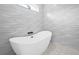 Elegant bathroom featuring a modern standalone tub, stylish tilework, and a bright window at 527 Rio Grande Dr, Poinciana, FL 34759