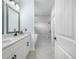Bathroom with double vanity, quartz countertops, hexagon tile flooring, and walk-in shower featuring textured accent wall at 527 Rio Grande Dr, Poinciana, FL 34759