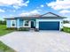Charming single-story home with a blue exterior, brick accents, and a spacious paver driveway at 527 Rio Grande Dr, Poinciana, FL 34759