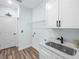 Well-lit laundry room featuring modern sink, countertop, white cabinetry, and ample storage space at 527 Rio Grande Dr, Poinciana, FL 34759