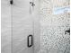 Modern shower featuring glass doors, wave tile accents, and a decorative rock wall at 527 Rio Grande Dr, Poinciana, FL 34759