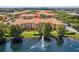 Aerial view of condo complex with a pond and fountain surrounded by manicured landscaping at 5467 Vineland Rd # 6110, Orlando, FL 32811