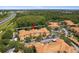An aerial view of a building complex with pond and parking, framed by lush greenery and a clear blue sky at 5467 Vineland Rd # 6110, Orlando, FL 32811