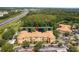 The aerial view shows the building overlooks a tranquil pond with a fountain, surrounded by mature trees and parking at 5467 Vineland Rd # 6110, Orlando, FL 32811