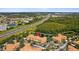 Aerial shot highlighting building's setting by a pond, adjacent to a highway and surrounded by dense trees at 5467 Vineland Rd # 6110, Orlando, FL 32811