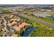 Aerial view of the property featuring beautiful landscaping, water feature, and a glimpse of the highway at 5467 Vineland Rd # 6110, Orlando, FL 32811