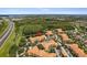 Aerial view captures a well-maintained community near a highway, enveloped by lush trees and serene lakes at 5467 Vineland Rd # 6110, Orlando, FL 32811