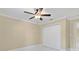 Bright bedroom features a ceiling fan, white tile floor, fresh paint and a closet for ample storage at 5467 Vineland Rd # 6110, Orlando, FL 32811