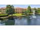 Exterior view of the building overlooking the pond and fountain, surrounded by lush landscaping at 5467 Vineland Rd # 6110, Orlando, FL 32811