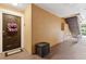 Hallway area featuring a solid front door with wreath, convenient storage box, and a staircase leading to upper levels at 5467 Vineland Rd # 6110, Orlando, FL 32811