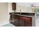 Cozy kitchenette features dark wood cabinets, black granite countertops, and a stainless steel sink at 5467 Vineland Rd # 6110, Orlando, FL 32811