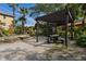 Community picnic area under wooden pergolas with seating, surrounded by lush tropical landscaping and a playground at 5467 Vineland Rd # 6110, Orlando, FL 32811