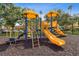 Community playground featuring bright yellow slides, climbing structures, and a cushioned ground surface at 5467 Vineland Rd # 6110, Orlando, FL 32811