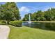 Scenic pond with a fountain surrounded by lush greenery and a paved walking path at 5467 Vineland Rd # 6110, Orlando, FL 32811