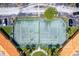 Aerial view of community tennis court, parking area and building, surrounded by green landscaping at 5467 Vineland Rd # 6110, Orlando, FL 32811