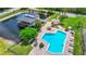 Aerial view of pool and pond featuring pool, outdoor seating, and surrounding landscape at 6052 Village Cir # 6052, Orlando, FL 32822